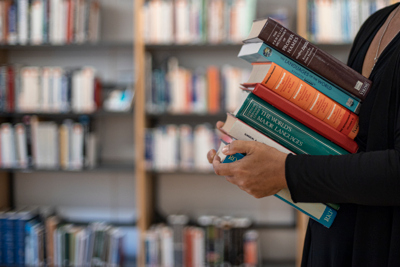 Kvinna håller boktrave i famnen. Foto: Björn Bjarnesjö.